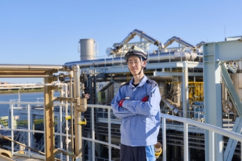 水再生センターの設備前に立つ社員