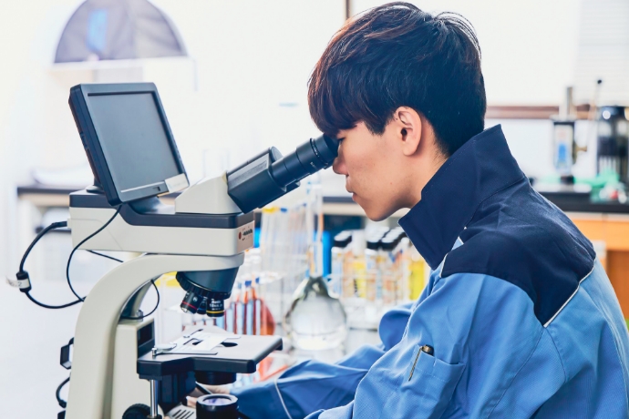 顕微鏡で水質検査をする社員