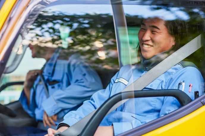 作業車内で笑顔の社員